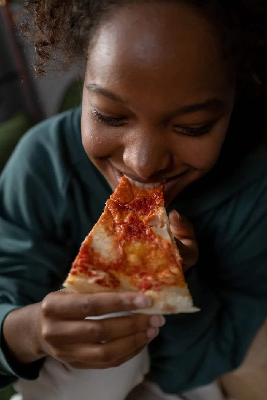 Une jeune femme savoure une part de pizza